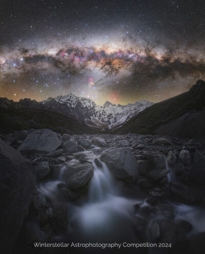 Super sharp image of galactic core of milky way over mountains and river in foreground.